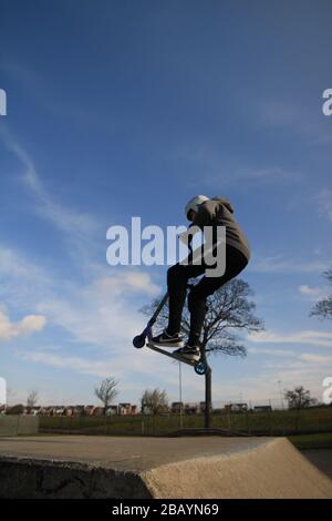 Youth scooter rider, england, uk, skate, skatepark, ramps, tricks, scooter, park, jumps, stunts. Stock Photo