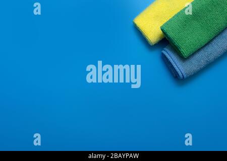 Colorful, dry microfiber cloths for different surfaces cleaning in kitchen, bathroom and other rooms, on blue background. Copy space. Cleaning service Stock Photo