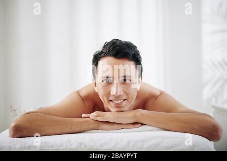 Mixed-race happy young man enjoying spending time in spa salon Stock Photo