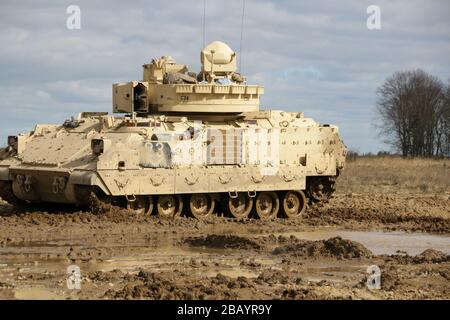 An M2A2 Bradley Infantry Fighting Vehicle assigned to Charlie Company, 3rd Battalion, 67th Armored Regiment, 2nd Armored Brigade Combat Team, maneuvers towards an objective during a table III Gunnery exercise at Drowsko Pomorskie Training Area, Poland, March 23. Table III Gunnery allows armored vehicle crews to exercise the fundamentals of scanning and maneuvering to maintain proficiency engaging targets in order to improve unit readiness. (U.S. Army photo by Sgt. Andres Chandler) Stock Photo