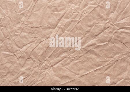 Crumpled paper texture in stylish beige color as part of your greeting card. Stock Photo