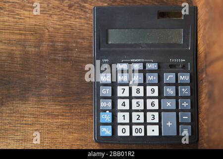 Black calculator on a dark wooden background Stock Photo