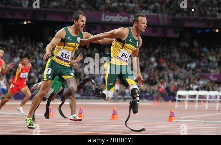 South Africa's Arnu Fourie hands over to Oscar Pistorius during the Men's 4x100m - T42/T46 on Day 6 of the London 2012 Paralympic Games in the Olympic Stadium, London. Stock Photo