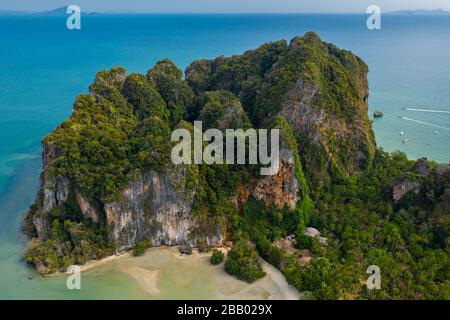 Aerial view of towering limestone cliffs and lush green jungle next to a tropical beach (Railay Beach, Thailand) Stock Photo