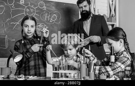 Science and education. chemistry lab. back to school. happy children teacher. children making science experiments. Education. doing experiments with liquids in chemistry lab. Doing research. Stock Photo