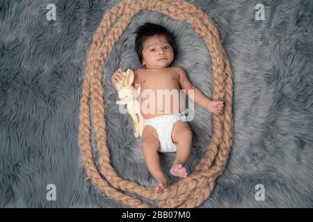 Child baby portrait . Sweet tot little child on a grey fur blanket. Awake Newborn with teddy bear Stock Photo