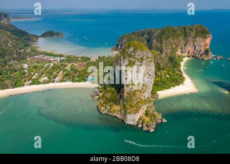 Aerial drone view of a beautiful tropical beach, towering cliffs and green jungle on an isolated peninsula. (Railay Beach, Krabi) Stock Photo