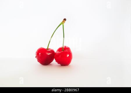 Two red cherries isolated on white background Stock Photo