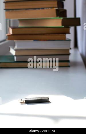 Flash drive on the background of books, result of progress Stock Photo
