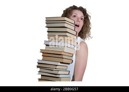 Cheerful student holding huge pile of books standing in library Stock ...