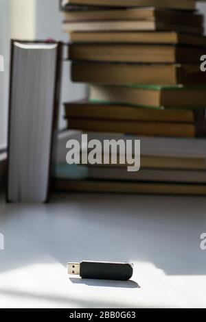 Flash drive on the background of books, result of progress Stock Photo