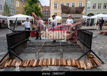 Entire cow being spit roasted whole in the streets of Copenhagen, Denmark, Europe Stock Photo