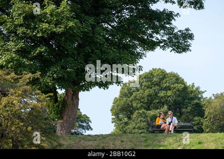 Man and woman sitting on a park bench Stock Photo