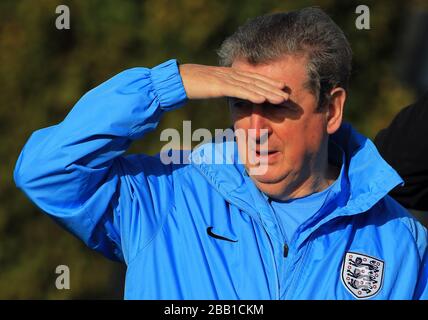 England Manager Roy Hodgson looks over to his players warming up as he speaks to the media Stock Photo