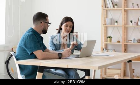 Focused businesspeople cooperating working together on laptop Stock Photo