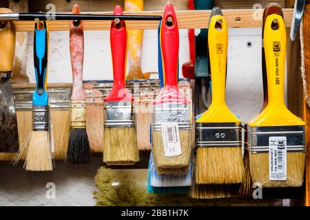 artist apron with paint brushes hanging on brick wall Stock Photo