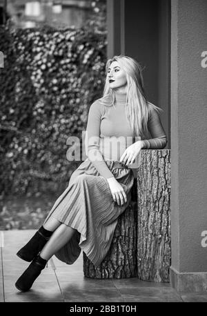 In her own style. must-have skirt. trendy girl wear corrugated skirt. pleated skirt collection. woman warm autumn skirt sit outdoor. relax while walking. enjoy casual day. Clothing features pleats. Stock Photo