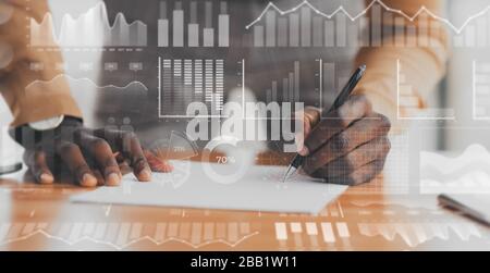 African American businessman working with document, collage with double exposure of graphs on digital screen Stock Photo