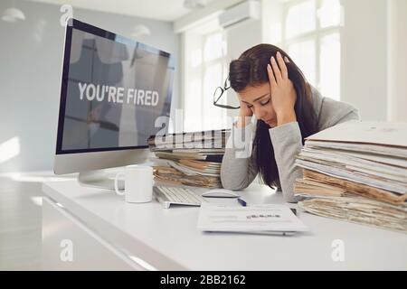You are fired. Unemployed woman unhappy frustrated depression sitting at the table. Stock Photo