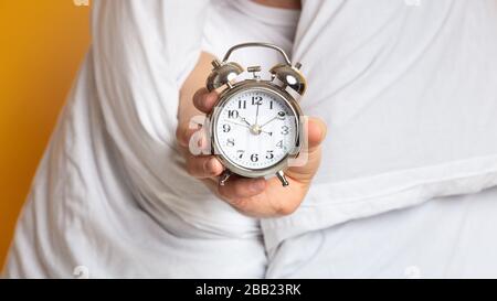 Man in blanket with an alarm clock Stock Photo