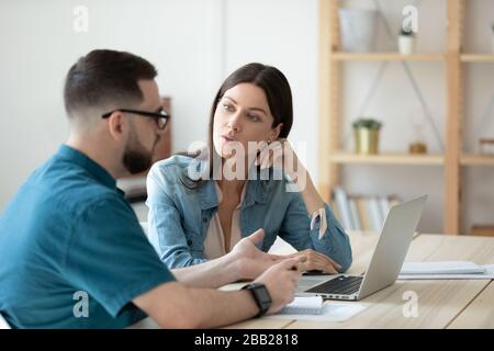 Diverse colleagues brainstorm using laptop at meeting Stock Photo