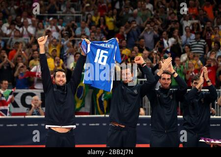 Italy's Cristian Savani (left) and Lugi Mastrangelo hold up a shirt for a team mate that sadly died during a game as the receive their Bronze Medals in the Men's Volleyball at London's Earl Court during the final day of the London 2012 Olympics. Stock Photo