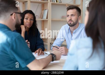 Multiracial businesspeople talk discuss ideas at briefing Stock Photo