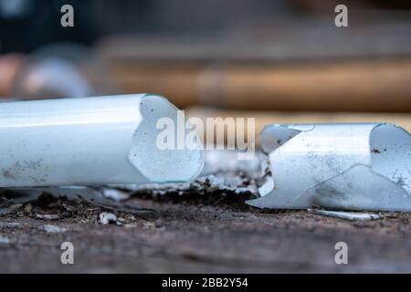 The Shattered glass tube, broken energy saving bulb, compact fluorescent lamp tubular type with blur background Stock Photo