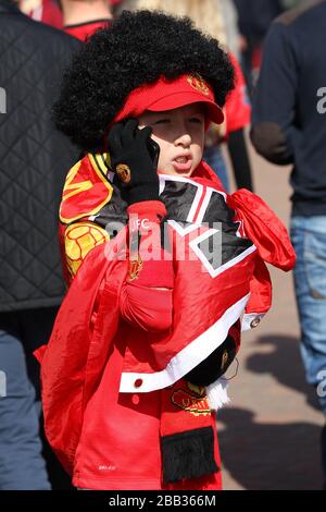 A young Manchester United fan wears a Marouane Fellaini wig outside Old Trafford Stock Photo