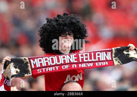 A young Manchester United fan wears a Marouane Fellaini wig in the stands Stock Photo