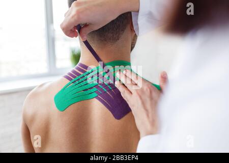 Kinesiology taping. Physical therapist applying kinesiology tape Stock Photo