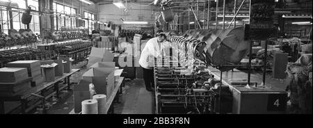 A worker supervising a machine at Tay Spinners mill in Dundee, Scotland. This factory was the last jute spinning mill in Europe when it closed for the final time in 1998. The city of Dundee had been famous throughout history for the three 'Js' - jute, jam and journalism. Stock Photo