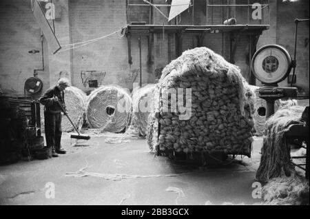 A worker sweeping the floor at Tay Spinners mill in Dundee, Scotland. This factory was the last jute spinning mill in Europe when it closed for the final time in 1998. The city of Dundee had been famous throughout history for the three 'Js' - jute, jam and journalism. Stock Photo