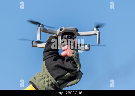 Drone Quadcopter during flight on a sunny day on blue sky background Stock Photo