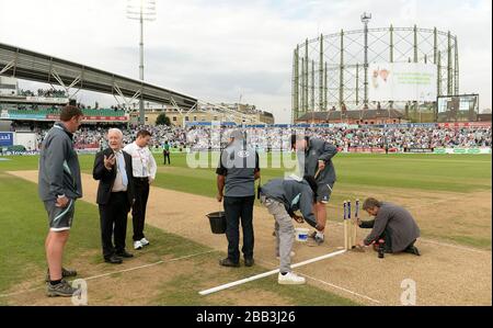 Former Surrey County Cricket head groundsman Bill Gordon (2nd left) inspects the Ashes wicket at the Kia Oval after becoming the first non-cricketer to receive a Surrey County Brown Cap Stock Photo