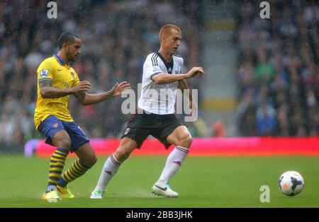 Fulham's Steve Sidwell (centre) and Arsenal's Theo Walcott (left) battle for the ball Stock Photo