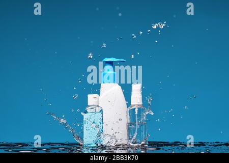 Bottle of antiseptic liquid soap, spray and gel in splashes of water. Concept of washing hand, hygiene and prevention measures from the Covid-19 Coron Stock Photo