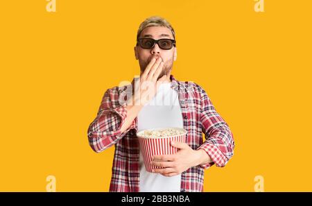 Guy in 3D glasses covers mouth with hand Stock Photo