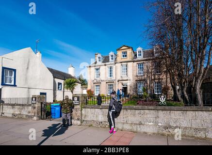 Haddington, East Lothian, Scotland, United Kingdom, 30th March 2020. Covid-19 Coronavirus lockdown impacts on the normally bustling market town on a beautiful Spring day with empty streets and people social distancing. People queue outside a Royal Bank of Scotland branch keeping 2m apart Stock Photo