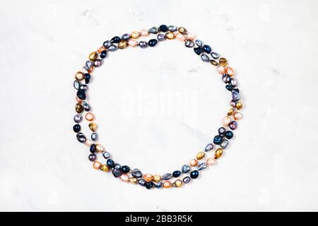 top view of hand crafted necklace from colored river pearls on gray concrete background Stock Photo