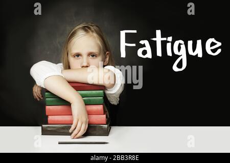 Sad Tired child girl with books. Fatigue concept Stock Photo