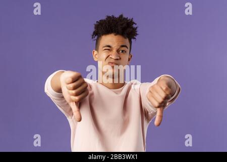 Close-up portrait of disappointed, unimpressed young hispanic man with dreads, grimacing skeptical, judging something bad, watched awful boring movie Stock Photo