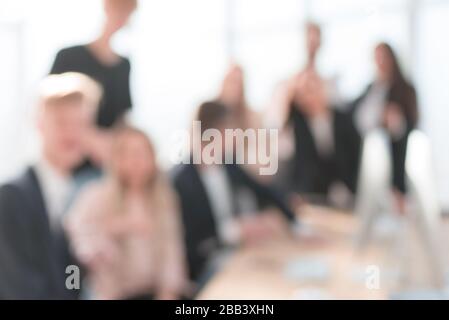 background image of a business team sitting at a Desk. Stock Photo