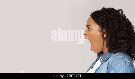 Angry african american woman screaming with rage at copy space Stock Photo