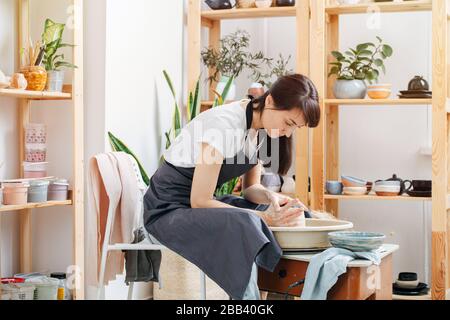 Sad woman distracted from problems engaged in pottery at home studio Stock Photo