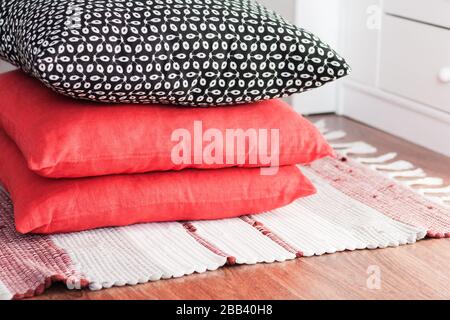 Cozy home interior decor, multi-colored rug, red and black decorative pillows Stock Photo