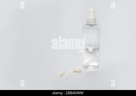 Spray trigger, white plastic pulverizer on white background with capsules pills. Sanitize spray cosmetics trigger. Aerosol transparent bottle close up Stock Photo