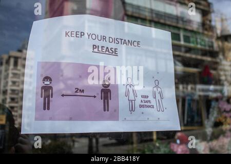 Beirut, Lebanon. 30 March 2020. A sign on a shop window advising the public to keep a safe distance  during a nationwide lockdown that has been extended until 12 April 2020 to stem the spread of covid-19 coronavirus.. Credit: amer ghazzal/Alamy Live News Stock Photo