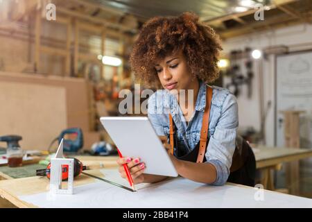 Afro american woman craftswoman working in her workshop Stock Photo