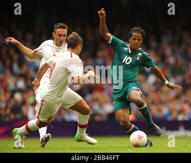 Mexico's Giovani dos Santos (right) takes on Switzerland's Francois Affolter (2nd left) during the Group B Men's Football match at the Millennium Stadium. Stock Photo